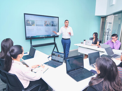 A business presentation taking place in a modern office environment with a focus on professional development and business training