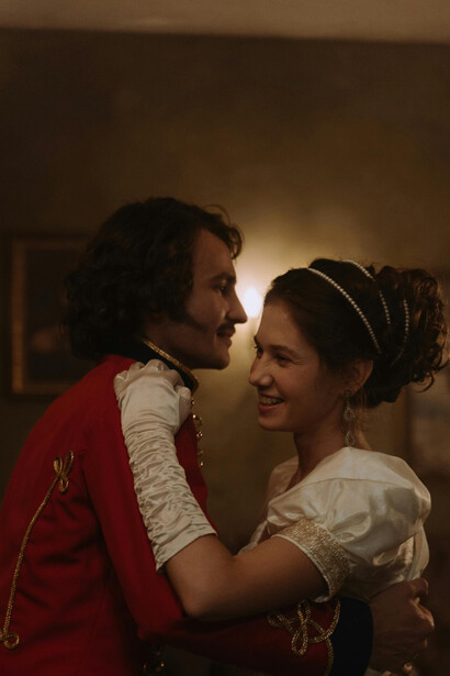 An artistic scene of an aristocratic couple dancing in a candlelit room, dressed in classic 18th-century fashion