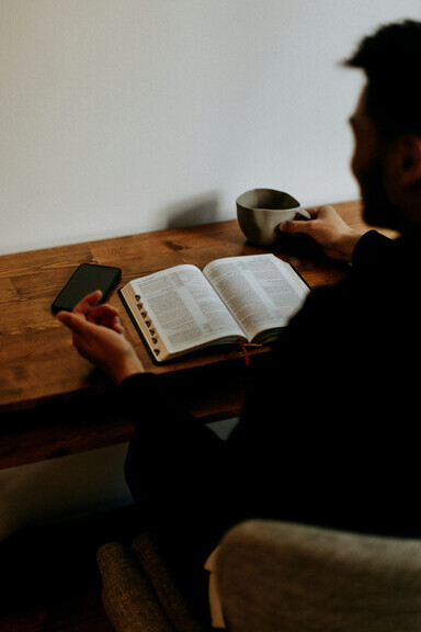 Deep in Bible study, a man reflects on scripture in church, navigating his spiritual struggle and finding redemption through faith