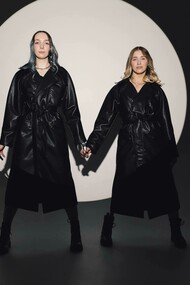 Modelle in trench di pelle nero su set fotografico