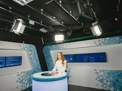 A TV presenter in the studio, preparing for a new broadcast, showcasing the media industry's dynamic environment