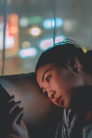 Moça rolando a tela de seu celular infinitamente como um hábito adquirido no cotidiano enclausurado