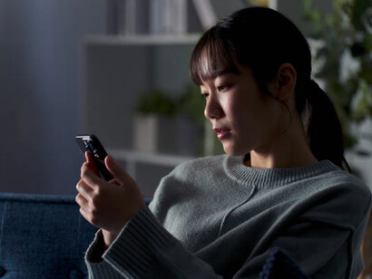 A woman scrolling through social media apps on her smartphone, experiencing feelings of depression and digital overwhelm