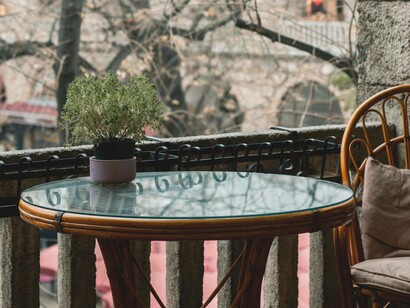 Un balcone in pietra che si affaccia su alberi spogli, l’atmosfera è silenziosa e suggestiva 
