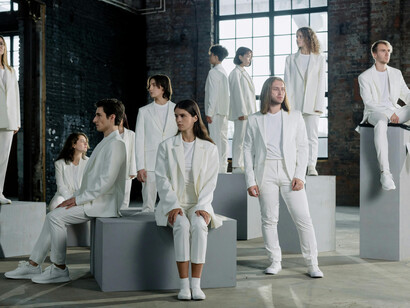 Fashion show with people in white outfits indoors