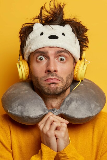 A neck pillow, good headphones, and a calm playlist—your best allies at 30,000 feet