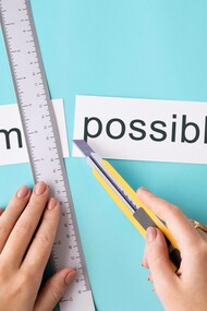 Mani di donna che tagliano in due parti la parola "impossibile": "Ho solo scoperto il segreto: fare quello che so essere necessario fare per essere chi desidero essere"