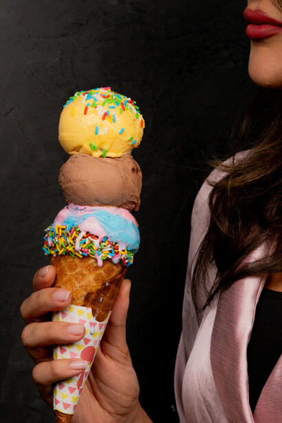 Close-up of a woman’s hand holding an ice cream cone with sugar sprinkles