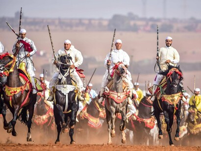 Traditional Moroccan Fantasia horsemen riding in unison, symbolizing collective intention and strategic coherence