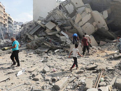 Palestinians inspect the ruins of Aklouk Tower after it was destroyed in Israeli airstrikes in Gaza City on October 8, 2023, Palestine