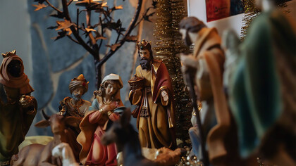 Tiny figurines of Jesus and Mary grace the Christmas setting, reminding us of the sacred origins of the holiday