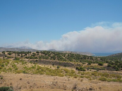 This image of smoke from a wildfire illustrates the "pervasive threat of forest fires" and the risks they pose to communities throughout Greece