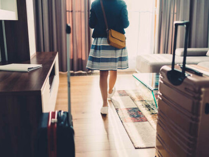 A solo female tourist enters her hotel room