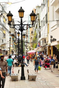 In the historic Ciudad Colonial district of Santo Domingo, Dominican Republic, pedestrians weave through markets and vendors, adding to the city's vibrant and bustling atmosphere