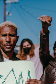 In the midst of a chaotic protest, people converge with a shared sense of urgency, reflecting a collective frustration that often overrides individual critical thinking