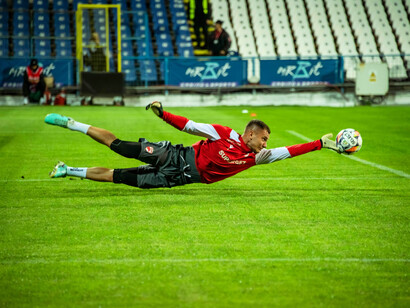 Un gardien de but réalise un plongeon spectaculaire pour arrêter le ballon pendant un match