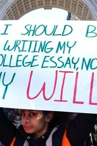 A young man holding up a pro-gun control sign 