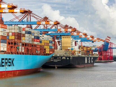 A cargo ship is docked at the harbour during the daytime